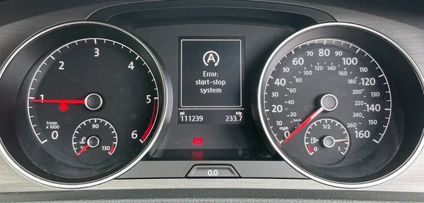 VW Golf dashboard with a start-stop system failure warning light illuminated